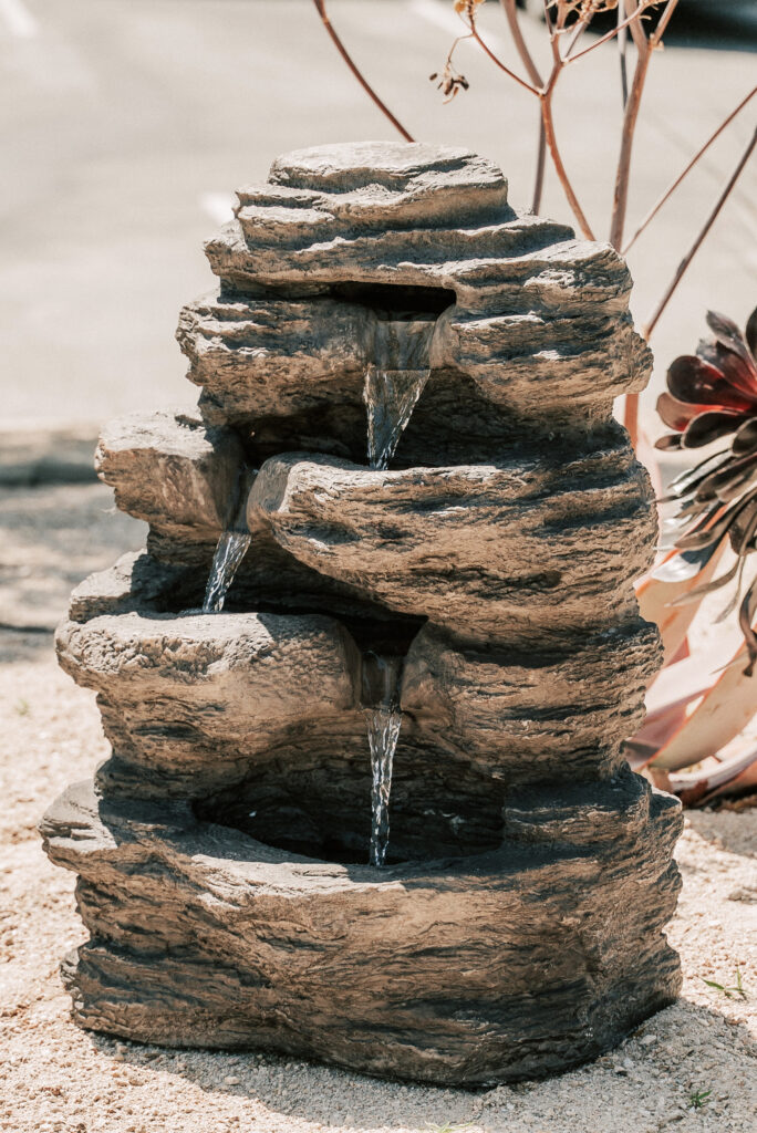 A rock fountain with water gently flowing from it, creating a soothing and tranquil ambiance in Temecula.